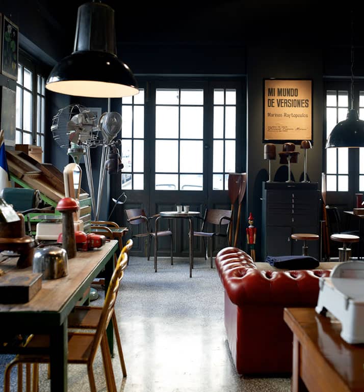 vintage industrial furniture and designer vintage interior by Alketas Pazis: the owner brought together a selection of vintage industrial chairs and tables (wood and metal), a vintage leather couch, vintage industrial lamps and a variety of retro decor items.