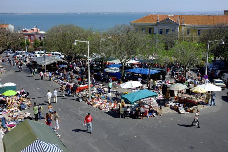 Shoppers exploring the winding stalls of the Lisbon Thieves Market