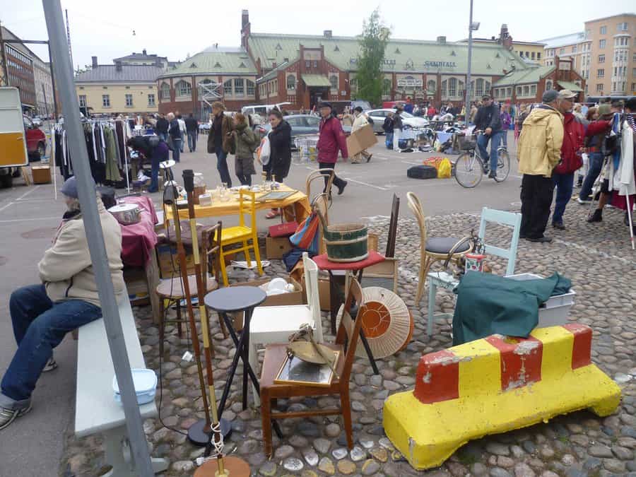 Helsinki flea market outdoor stalls with vintage items and browsers on a summer day