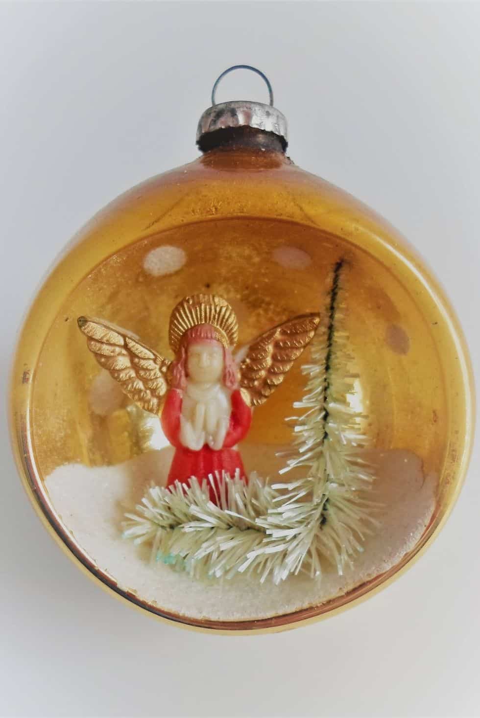 Vintage diorama Christmas ornament with a miniature winter village scene inside